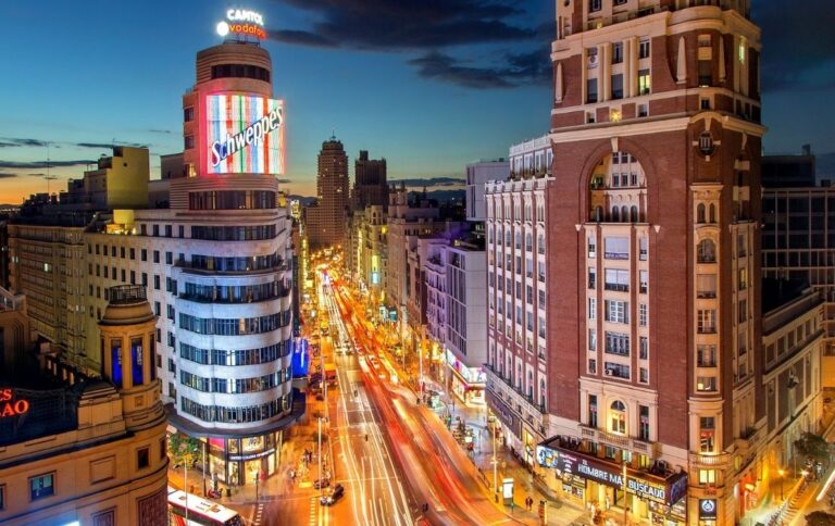Vista panorámica de la Gran Vía de Madrid iluminada al atardecer, cerca de Malasaña y de Look My Locker.