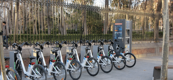 Estación del servicio BiciMAD junto al Parque del Retiro de Madrid, con bicicletas eléctricas listas para alquilar.