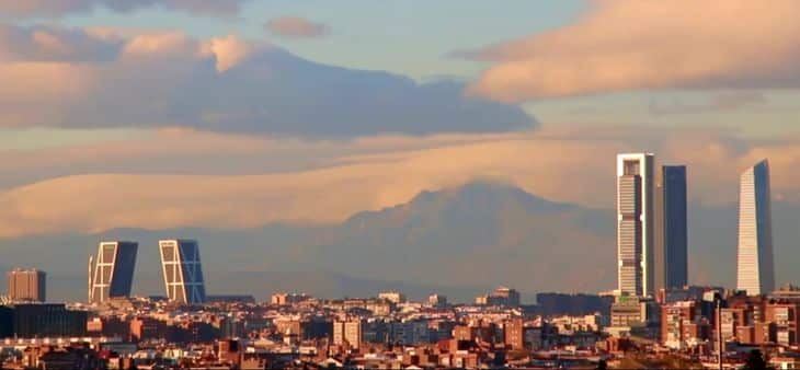 Skyline de Madrid con las Cuatro Torres y las Torres KIO al atardecer, con la Sierra de Guadarrama al fondo.