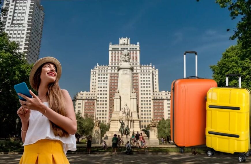 Turista con móvil y maletas frente al Monumento a Cervantes en la Plaza de España de Madrid.