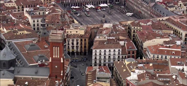 Vista aérea del centro histórico de Madrid con la Plaza Mayor al fondo y los tejados tradicionales de la ciudad.