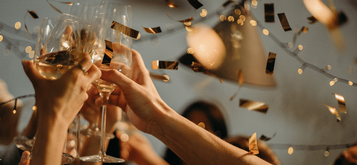 Brindis con copas y confeti dorado durante una celebración de Año Nuevo.