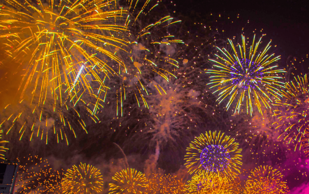 Fuegos artificiales de colores iluminando el cielo nocturno durante una celebración.