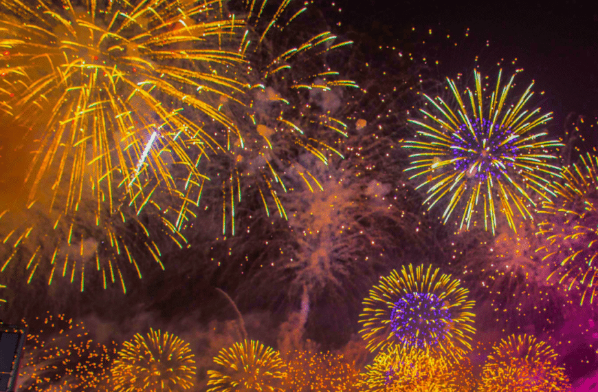 Fuegos artificiales de colores iluminando el cielo nocturno durante una celebración.