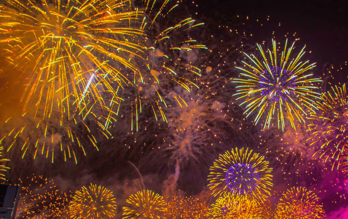 Fuegos artificiales de colores iluminando el cielo nocturno durante una celebración.
