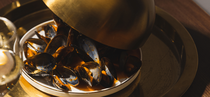 Plato de mejillones en restaurante de Madrid con presentación elegante.