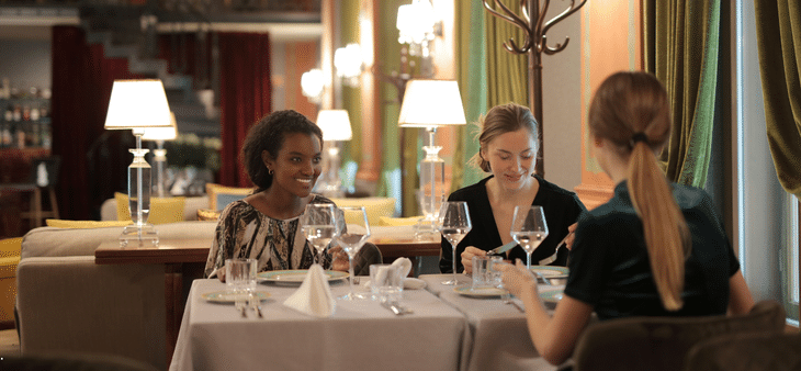 Tres mujeres disfrutando de una cena en un restaurante elegante en el centro de Madrid.